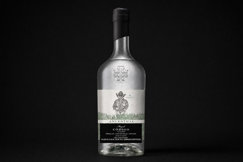 Bottle of Código 1530 Ancestral Mezcal with two glasses